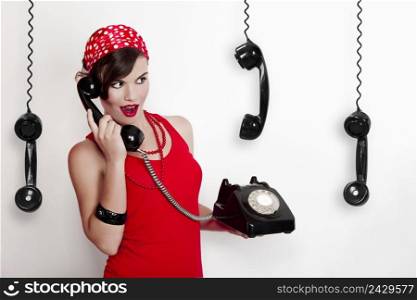 Beautiful and fashion young woman with a pin-up look. posing with a vintage phone