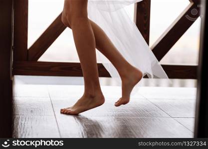 Beautiful and fashionable long-legged bride and in veil on the balcony. wedding morning.. Beautiful and fashionable long-legged bride and in veil on the balcony. wedding morning