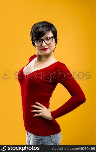 Beautiful and funny girl wearing nerd glasses, aganist a yellow background