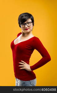 Beautiful and funny girl wearing nerd glasses, aganist a yellow background