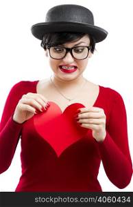 Beautiful and funny nerd girl ripping a paper heart, isolated on white background