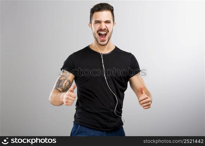 Beautiful and happy latin man listen music with thumbs up
