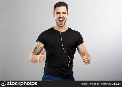 Beautiful and happy latin man listen music with thumbs up
