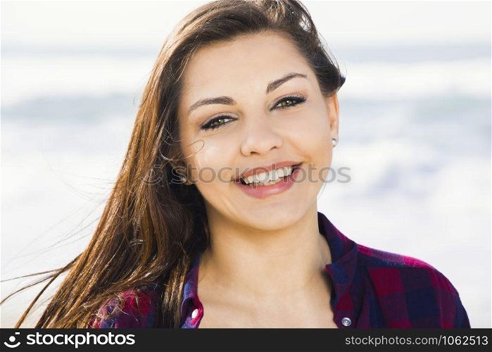 Beautiful and happy teen at the beach enjoying the summer
