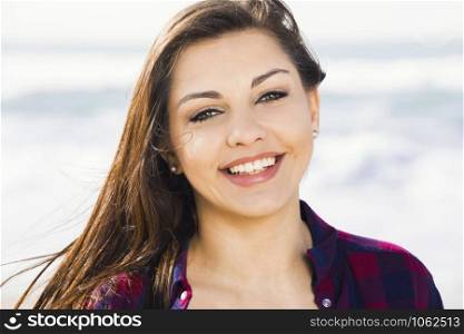 Beautiful and happy teen at the beach enjoying the summer
