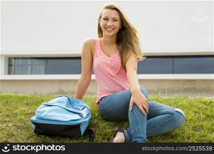 Beautiful and happy teenager sitting in the grass
