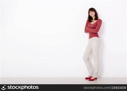 Beautiful and happy woman, against a white wall with copyspace on the left side.