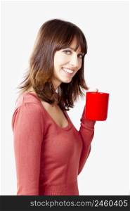 Beautiful and happy woman holding a cup of coffee, isolated on a gray background