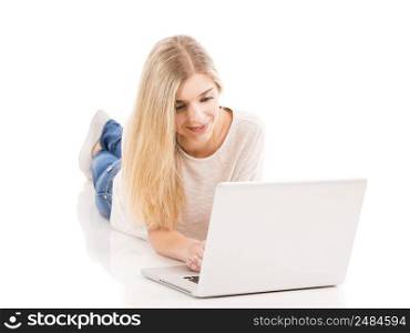 Beautiful and happy woman lying on the floor and working with a laptop, isolated over white background