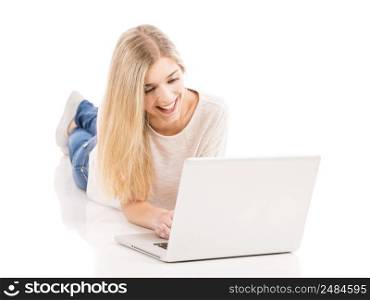 Beautiful and happy woman lying on the floor and working with a laptop, isolated over white background