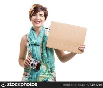 Beautiful and happy woman with a vintage camera and holding a cardboard, isolated over white background