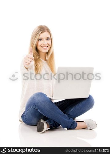 Beautiful and happy woman working on a laptop with thumbs up, isolated over white background