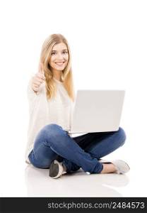 Beautiful and happy woman working on a laptop with thumbs up, isolated over white background