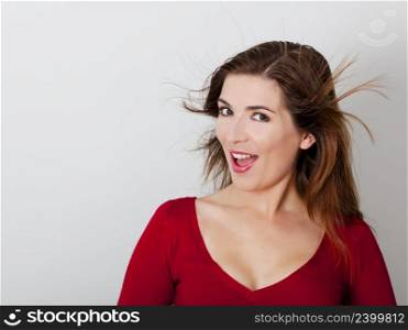 Beautiful and happy young woman against a gray wall