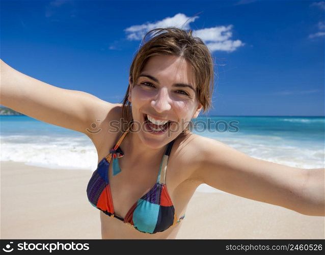 Beautiful and happy young woman enjoying the summer on a tropical beach
