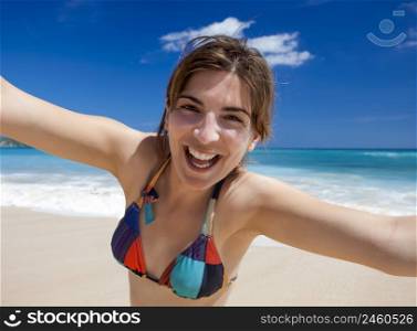 Beautiful and happy young woman enjoying the summer on a tropical beach