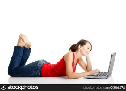 Beautiful and happy young woman lying on floor and working on a laptop