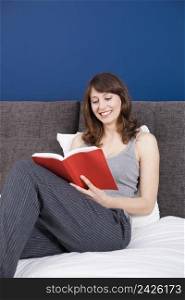 Beautiful and happy young woman reading a book
