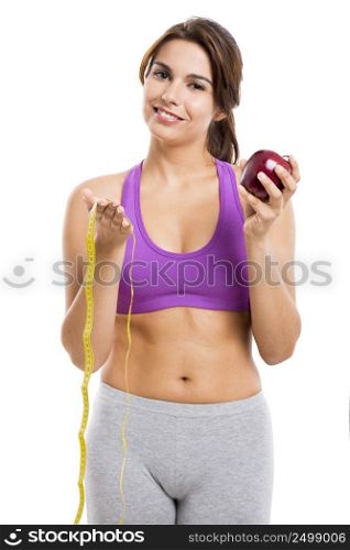 Beautiful and healthy woman holding an apple and a measure tape, isolated over white background