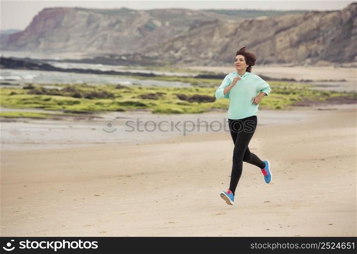 Beautiful and healthy woman running on the beach
