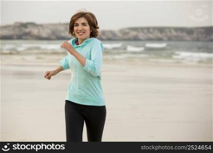 Beautiful and healthy woman running on the beach