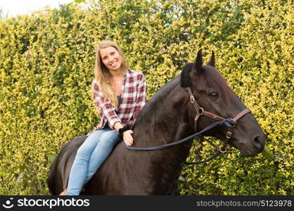 Beautiful and natural young woman spending sometime with her horse