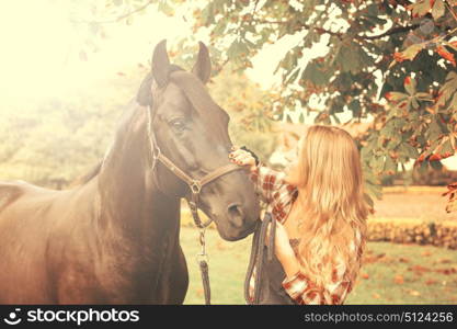 Beautiful and natural young woman spending sometime with her horse