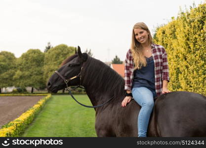 Beautiful and natural young woman spending sometime with her horse