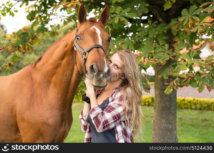 Beautiful and natural young woman spending sometime with her horse