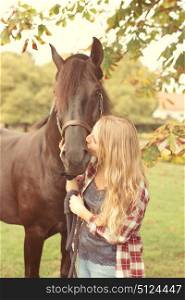 Beautiful and natural young woman spending sometime with her horse