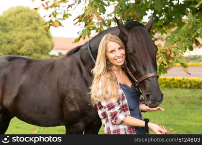 Beautiful and natural young woman spending sometime with her horse