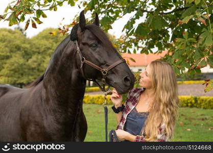 Beautiful and natural young woman spending sometime with her horse