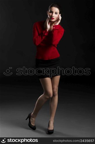 Beautiful and sexy fashion woman in studio, over a dark background