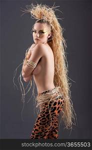 beautiful and sexy girl with raffia hair and a ethnic jungle costume in a shot over dark with creative make up