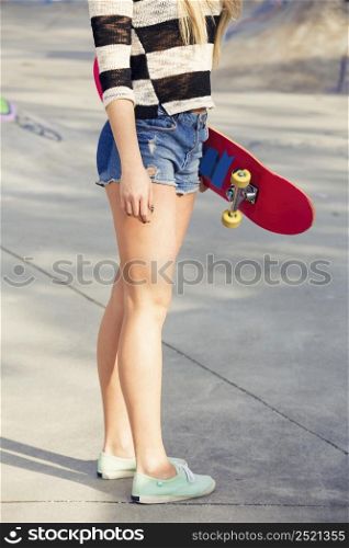 Beautiful and sexy street girl posing with her skateboard