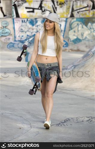 Beautiful and sexy street girl with her skateboard