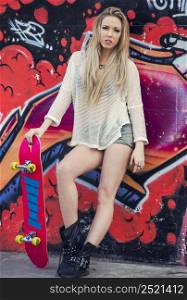 Beautiful and sexy street girl with her skateboard