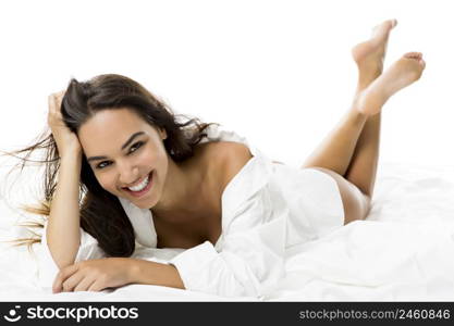 Beautiful and sexy woman lying on bed and smiling, isolated on white background