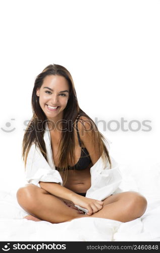 Beautiful and sexy woman sitting on bed and smiling