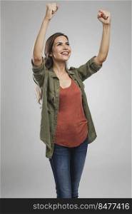 Beautiful and successful young woman with arms raised