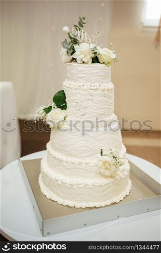 Beautiful and tasty wedding cake at wedding reception. Wedding cake, on white table. Beautiful and tasty wedding cake at wedding reception. Wedding cake, on white table.