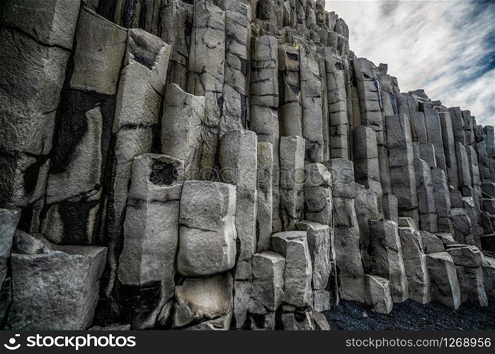 Beautiful and unique volcanic rock formation on Iceland black sand beach located near the village of Vik i myrdalin South Iceland. Hexagonal columnar rocks attract tourist who visit Iceland.