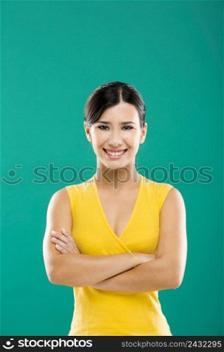 Beautiful and young asian woman smiling, over a green background