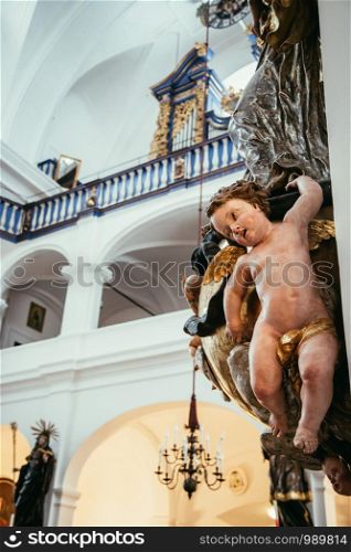 Beautiful angel sculpture in a baroque church, organ in the background