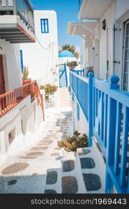 Beautiful architecture building exterior with cycladic style in Greece. The narrow streets of the island with blue balconies, stairs and flowers in Greece.