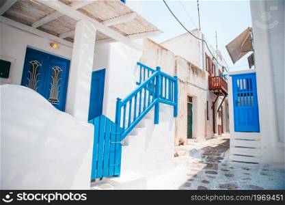 Beautiful architecture building exterior with cycladic style in Greece. The narrow streets of the island with blue balconies, stairs and flowers in Greece.