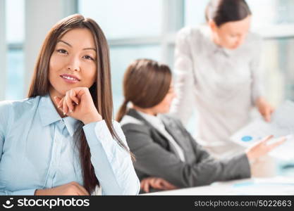 Beautiful asian business woman relaxing during a meeting at office with her colleagues