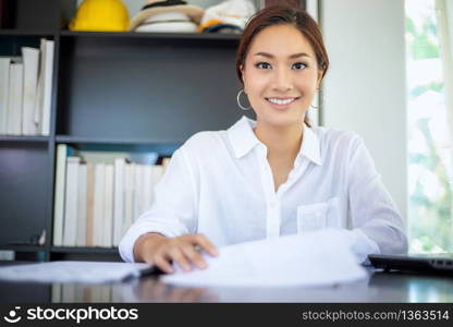 Beautiful Asian business women checking document and using notebook working from home for social distance and self responsibility concept