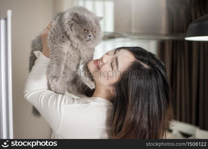 Beautiful asian cat lover woman is playing with cat in her room