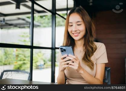 Beautiful Asian female hands holding and typing to communicate with others through on mobile phone, young woman using smartphone for shopping online at cafe coffee shop near windows in morning